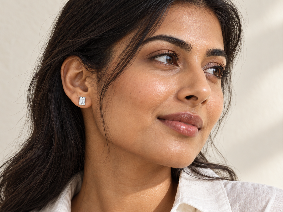 Woman wearing a Myraé moissanite ring against a soft ivory background