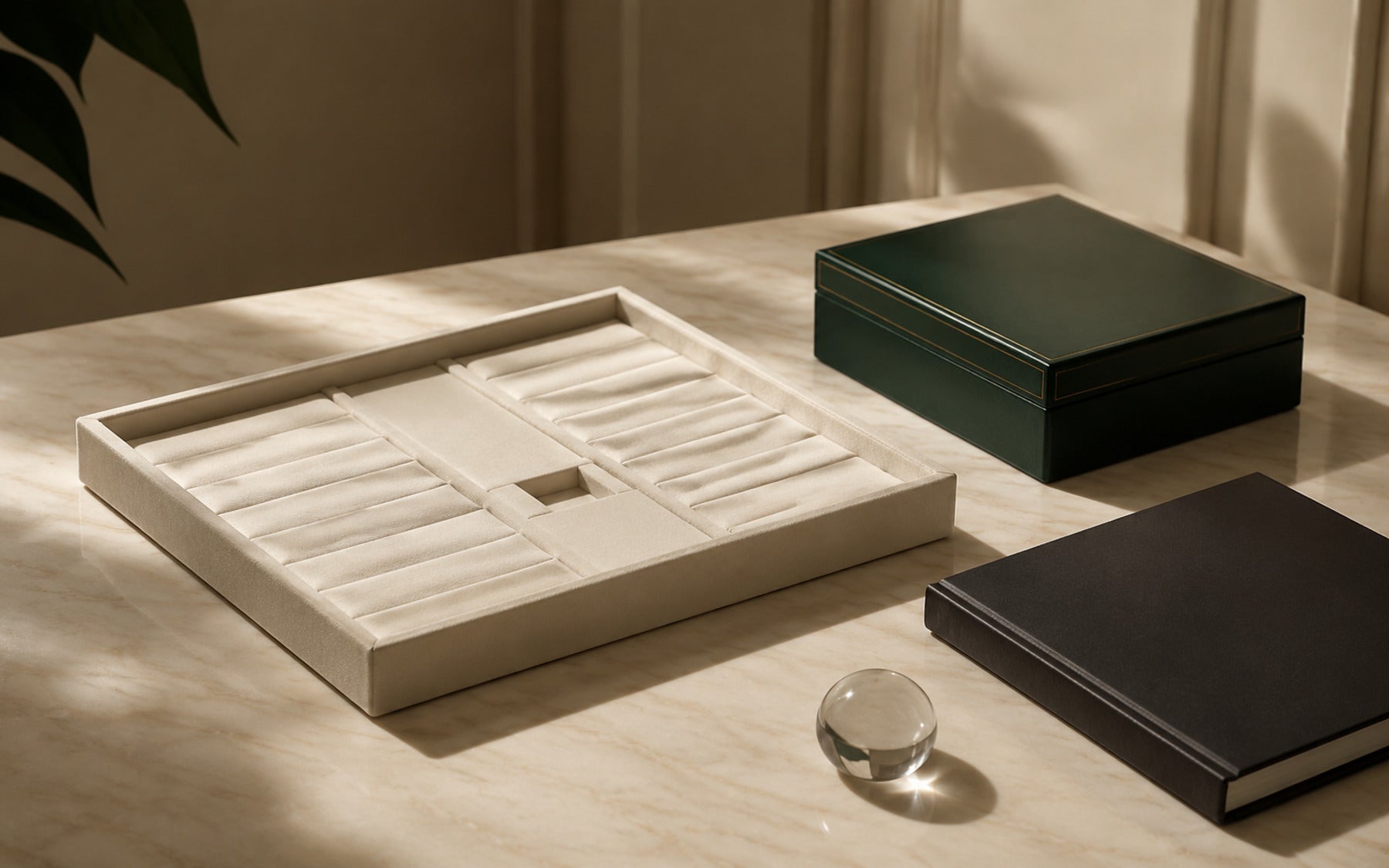 Empty jewellery display tray beside closed presentation boxes and ledger